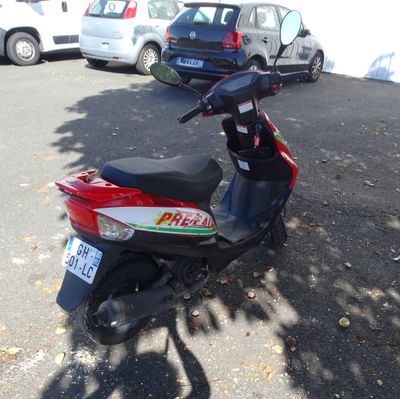 a scooter parked in a parking lot with cars in the background