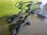 trois vélos d'appartement dans une salle de sport aux murs verts