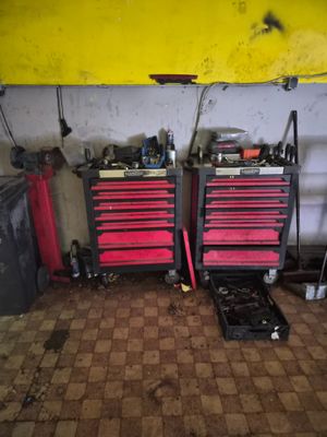two red tool boxes and a yellow surfboard in a garage