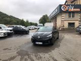 une voiture noire garée sur un parking devant un immeuble