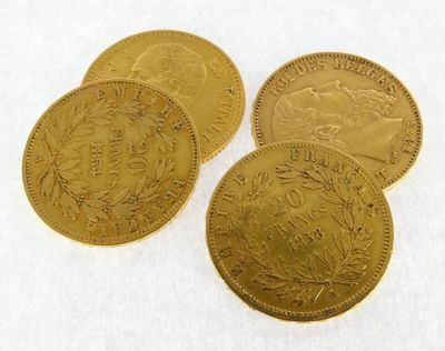 four gold coins are sitting on top of a white surface