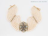 an image of a close up of a necklace with pearls and a broocher