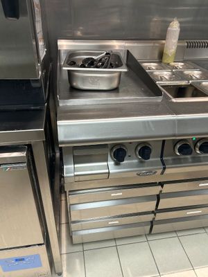 une cuisine en inox équipée d'une cuisinière et d'un lave-vaisselle