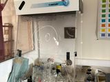 un laboratoire où s'entassent de nombreuses bouteilles sur le plan de travail