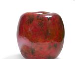 a red apple that is sitting on a white surface
