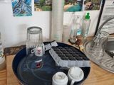a wooden table with a blue tray and a glass container on it