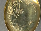 a gold plate with a picture of birds and flowers on it