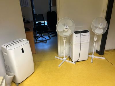 une pièce équipée de deux ventilateurs et d'un petit climatiseur