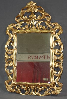 un miroir avec un cadre doré posé sur une surface grise