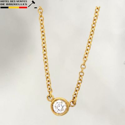 un collier en or avec un diamant blanc monté sur une chaîne