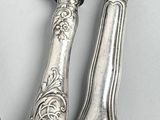 three silver spoons and a knife on a table