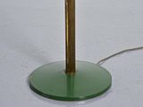 a green glass table lamp with a gold pole on it