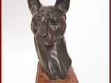 statue d'un chat assis sur un socle en bois, sur fond blanc