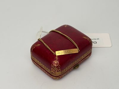 une petite boîte rouge ornée d'une chaîne dorée