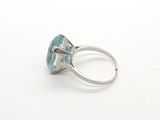a close up of a ring on a white surface with a blue stone