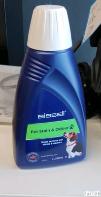 une photo d'un flacon de produit anti-taches pour chiens posé sur un plan de travail