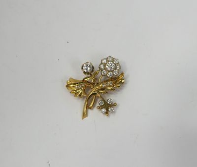 a close up of a gold brooch with flowers and leaves