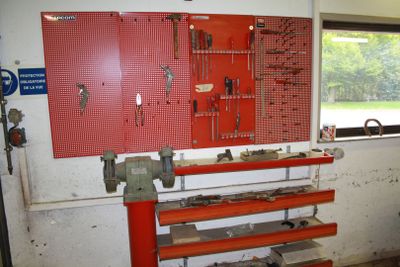 a red work bench with tools on it in a garage