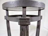 a metal table with a glass top on a white floor