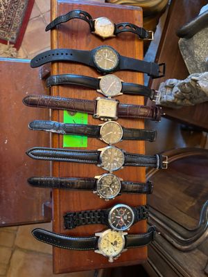 de nombreuses montres posées sur un présentoir en bois