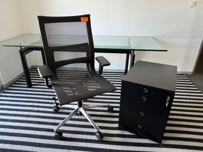 une chaise et un bureau dans une pièce où se trouve un tapis rayé