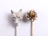 two pins with a cat ' s head and a tiger ' s head on them