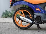 a blue and orange motorcycle parked on the side of the street