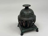 an antique bronze incense burner on a stand with a lid