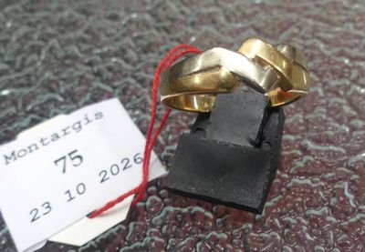 une bague en or posée sur un présentoir noir, avec une étiquette de prix
