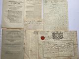 Plusieurs vieux papiers sont posés sur une table, portant un cachet de cire