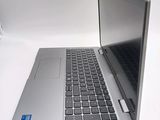 un ordinateur portable argenté posé sur une surface blanche