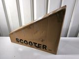 une boîte en carton sur laquelle est posé un scooter