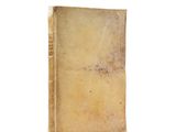 an old book sitting on top of a table on a white surface