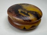 a wooden box with a painting on it on a table