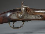 a close up of a gun on a table with a gray background