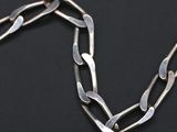 a close up of a silver chain on a black surface