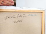 someone is writing on a piece of fabric with a bottle of beer