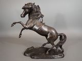 statue en bronze représentant un cheval dressé sur ses pattes arrière, posée sur un socle