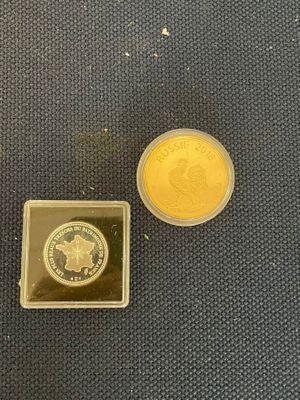 a gold coin and a silver coin sitting on a table