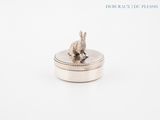 silver plated rabbit on a coin box with a white background