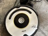 a close up of a robot on the floor with a cord