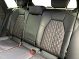 the back seats of a car with black leather and red stitching