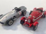 two toy cars sitting next to each other on a white surface