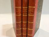 three red books are stacked on top of each other on a table