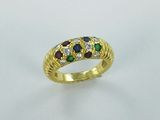 a close up of a gold ring with multi colored stones