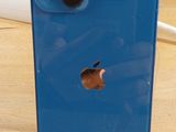 un iPhone bleu posé sur une table en bois