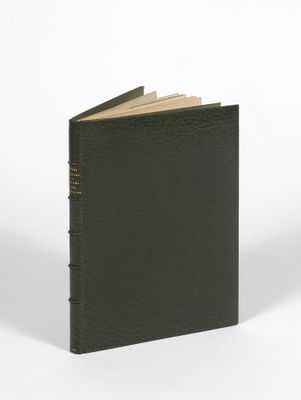un livre noir à la couverture marron posé sur une surface blanche