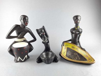 three figurines of women sitting on top of a table next to each other