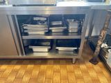 many pans and pans on a metal shelf in the kitchen