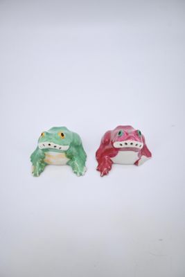 deux figurines représentant une grenouille et une autre grenouille, posées sur un fond blanc